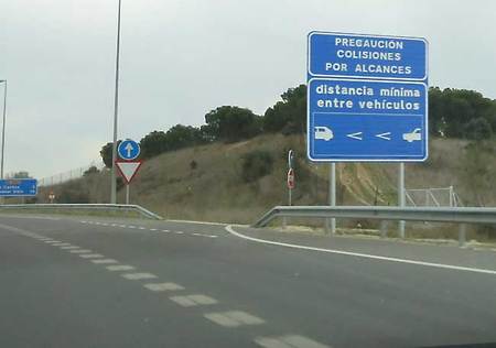 Cartel en la M-607 de Madrid anunciando un tramo con señalización de la distancia de seguridad pintada en la calzada en un tramo de concentración de accidentes
