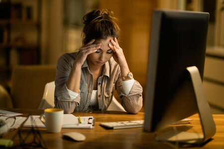 Mujer afectada por el burnout en el trabajo, ante un ordenador.
