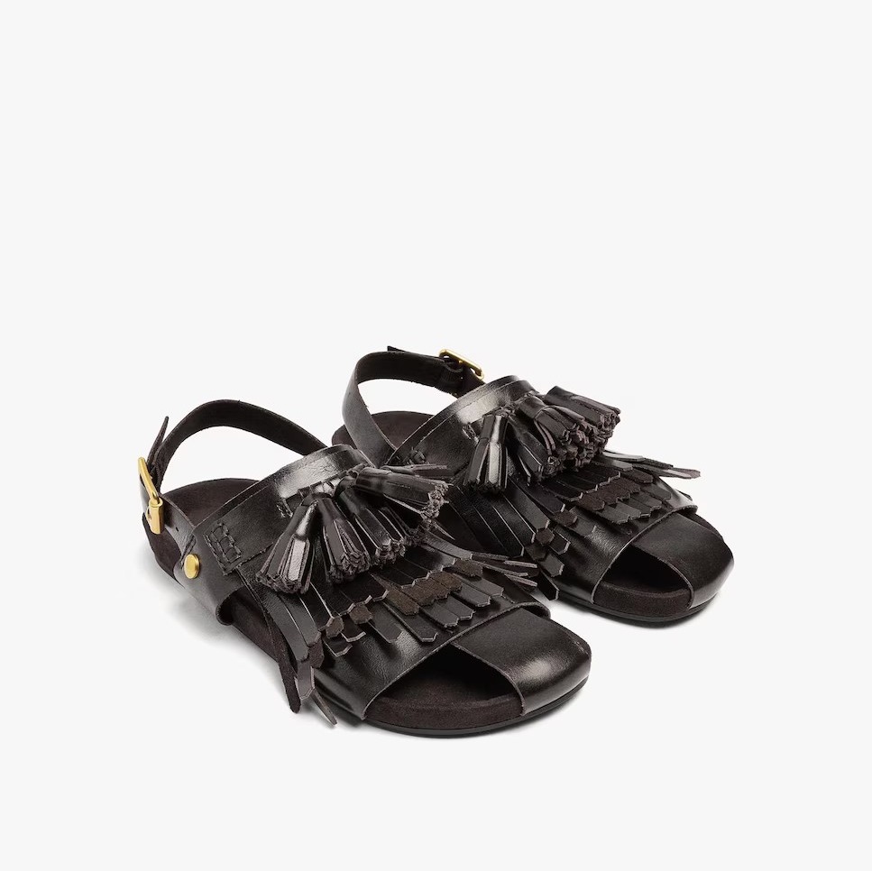 Zuecos planos de piel destalonados con flecos y borlas decorativas de Parfois

