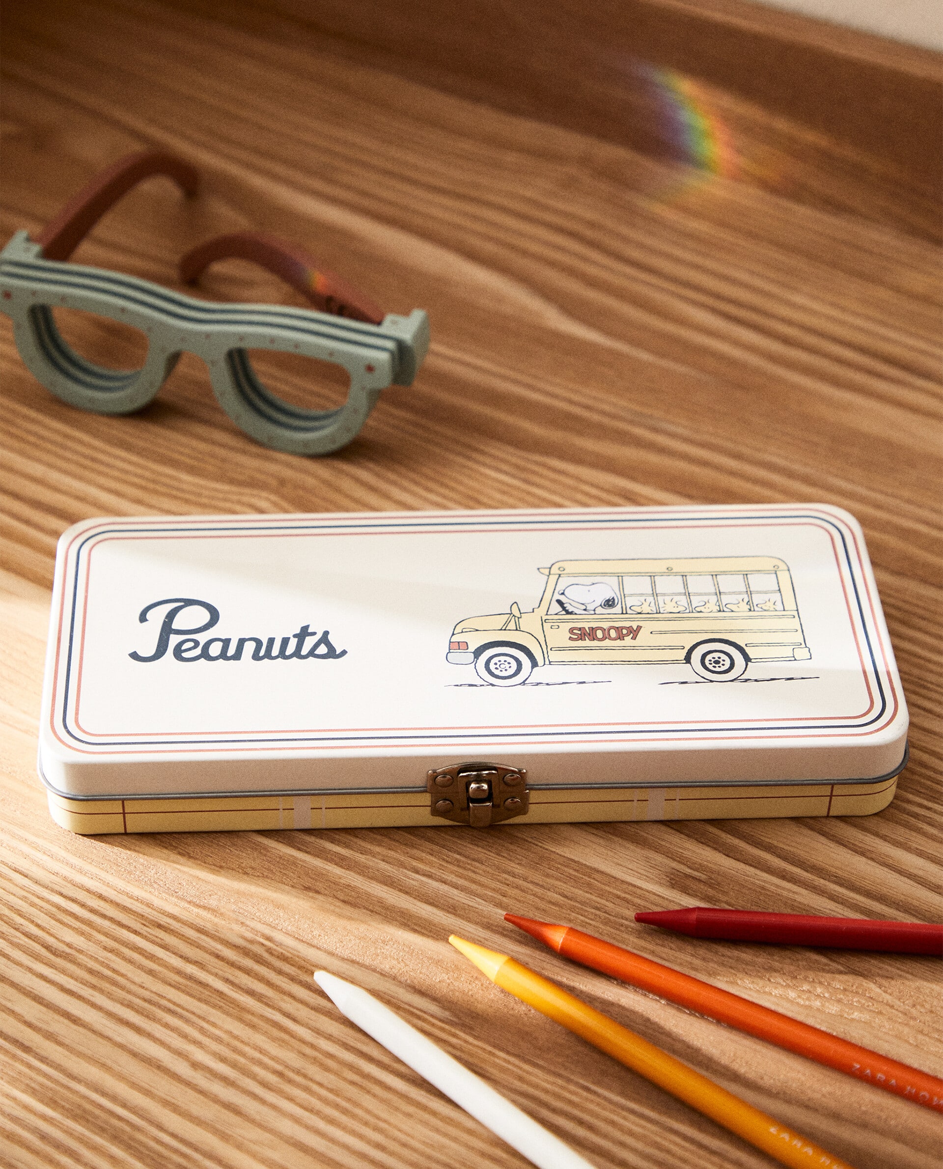 Estuche metálico con cierre de caja, forma rectangular y motivos de Peanuts, inspirados en la vuelta al cole.