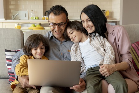 Familia Mirando Juntos En Un Portatil En Casa