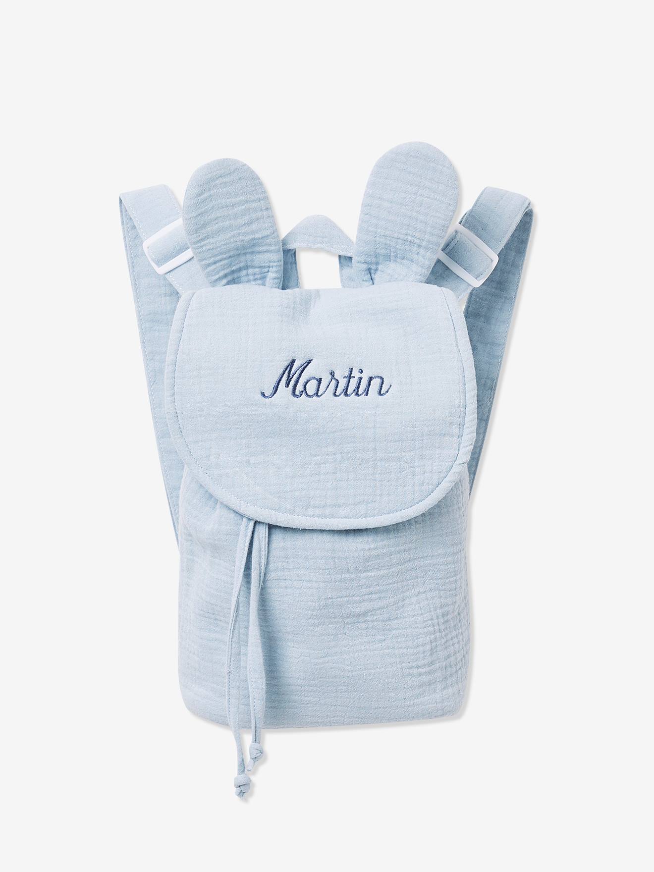 Mochila de medidas 23 x 27 x 10 cm. Dos tirantes ajustables, un asa para colgarla y cierre mediante cordón y solapa con tira autoadherente.