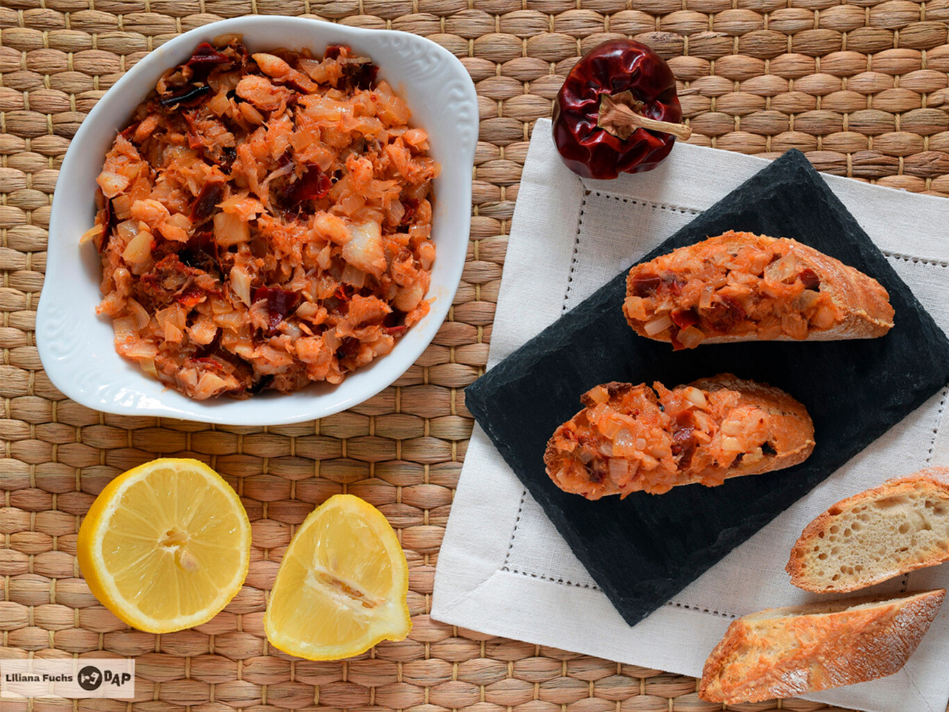 Plato de rin ran de bacalao con bacalao desmenuzado, ñoras y cebolla en una sartén tradicional