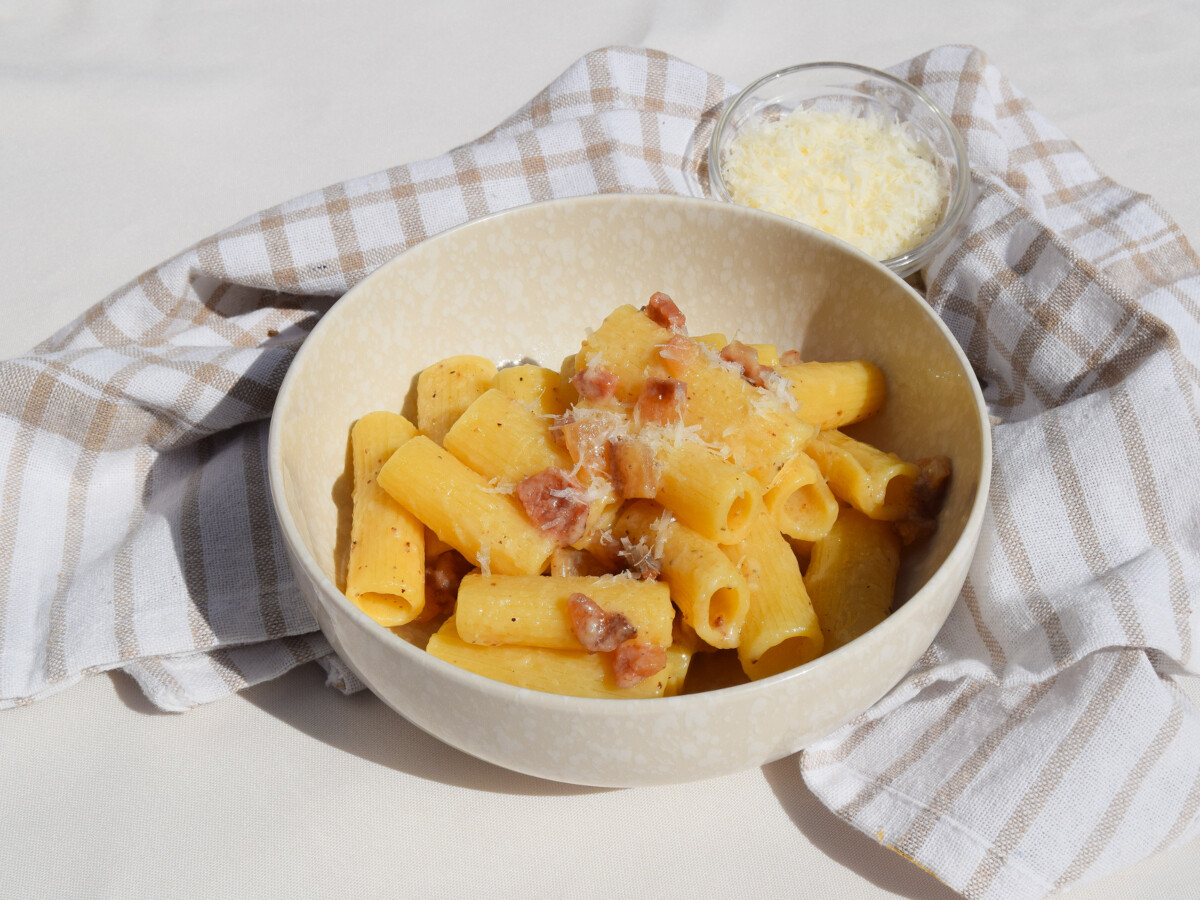 Plato de pasta alla gricia con rigatoni, guanciale dorado y salsa cremosa de pecorino