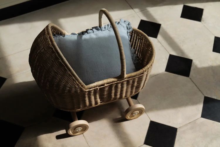 Carrito de juguete fabricado en ratán con ruedas de madera. Es el accesorio ideal para pasear a las muñecas.