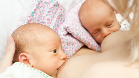 Mamá dando de mamar a sus dos bebés em posicion Balon Rugby Doble
