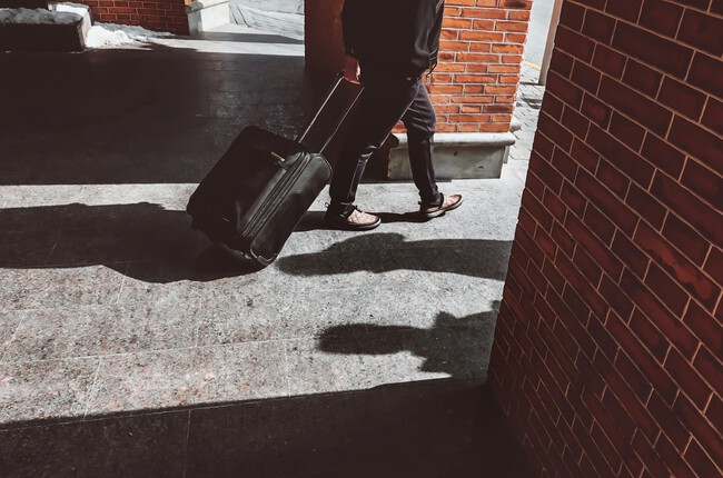 Hombre llevando una maleta con ruedas