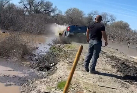 Una Chevrolet Silverado y una Ford F 150 convertidas en dique improvisado