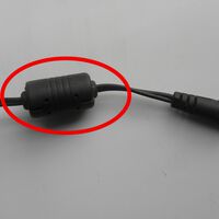 Aquele "cilindro" no cabo do seu notebook não está ali de enfeite: o "escudo invisível" que salva a vida do seu computador todos os dias 