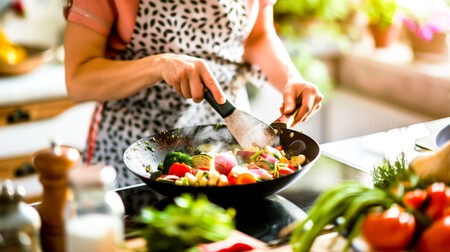 Una Mujer En Su Cocina Rodeada De Ingredientes Frescos Vuelve Habilmente Las Verduras En Un Wok Para Una Deliciosa Salsa Frita