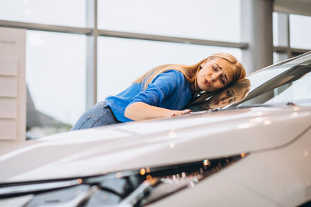 Mujer abrazándose a su coche nuevo