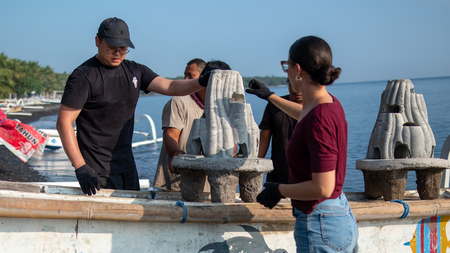 Pessoas manuseando um recife artifcial.