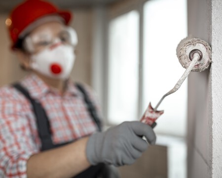 Trabajador De La Construccion Femenina Con Casco Y Rodillo De Pintura