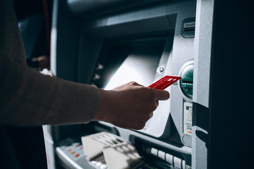 Pessoa fazendo saque no caixa eletrônico. Créditos: banco de imagens