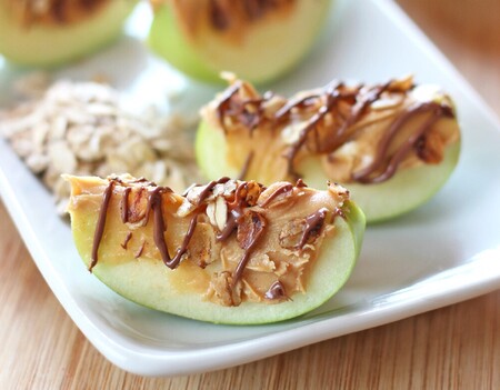 Gajos de manzana con crema de cacahuate, avena tostada y chocolate. Receta para niños