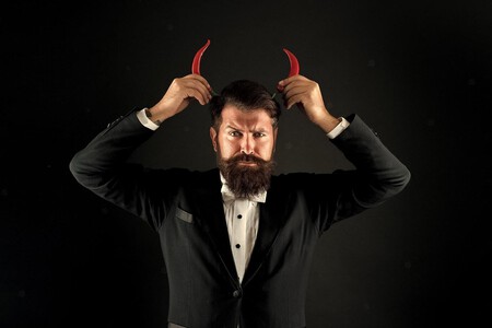 Hombre de negocios poniéndose unos cuernos de demonio