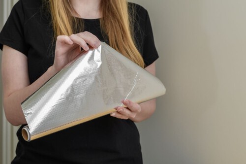 mulher segurando rolo de papel alumínio