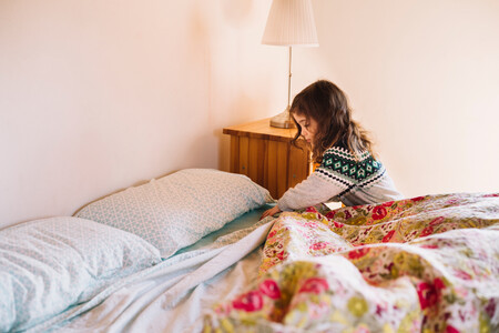 Girl Arranging Bedsheet In Bedroom