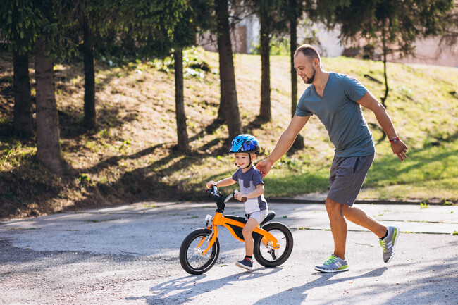 Father Teaching His Little Son To Ride Bicycle