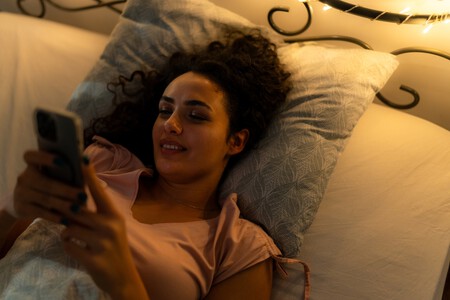 mulher mexendo no celular na cama