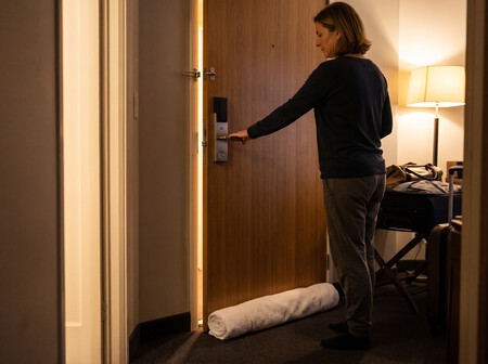 Mulher verificando se a porta do quarto do hotel está realmente trancada