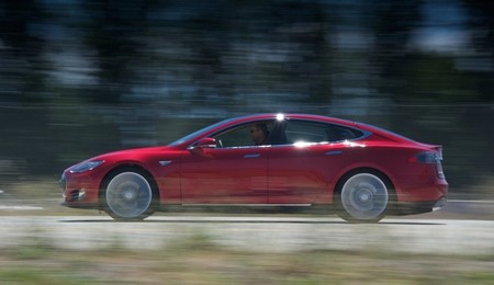 Tesla Model S rojo en carretera de perfil