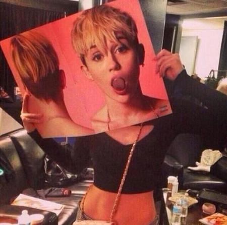 Miley Cyrus lleva un cartel luminoso que le dice a los chicos "¡Quita bicho!"