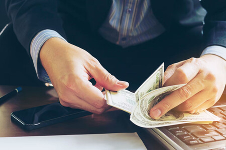 Persona contando dinero. Es importante analizar las matemáticas de los timos