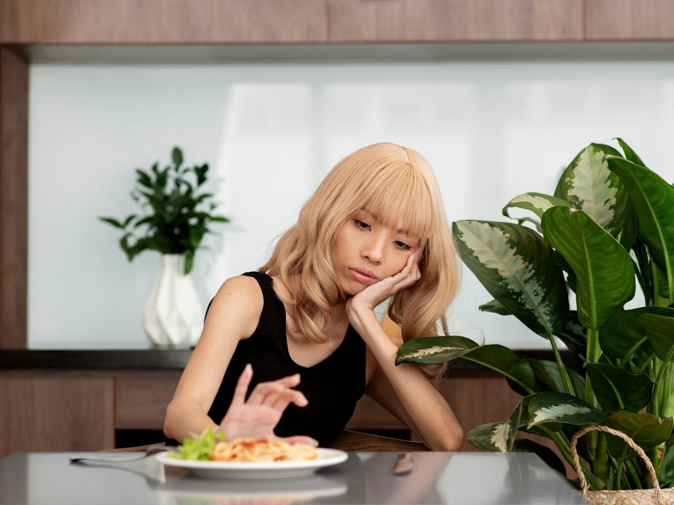Persona mirando un plato de comida con expresión de malestar o rechazo