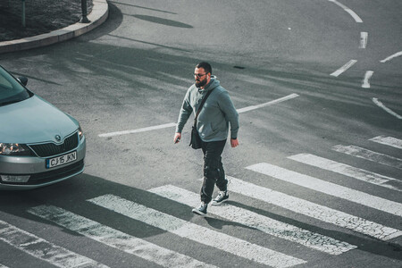 Hombre Cruzando La Calle Por Un Paso Cebra Delante De Un Skoda Gris