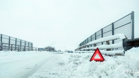 Coche atrapado en carretera nevada