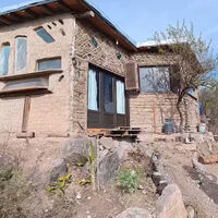 A los 22 años dejó la ciudad para construir su propia casa en las montañas con 12 cristales de parabrisas y materiales reciclados 