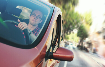 Conductor de coche circulando en ciudad