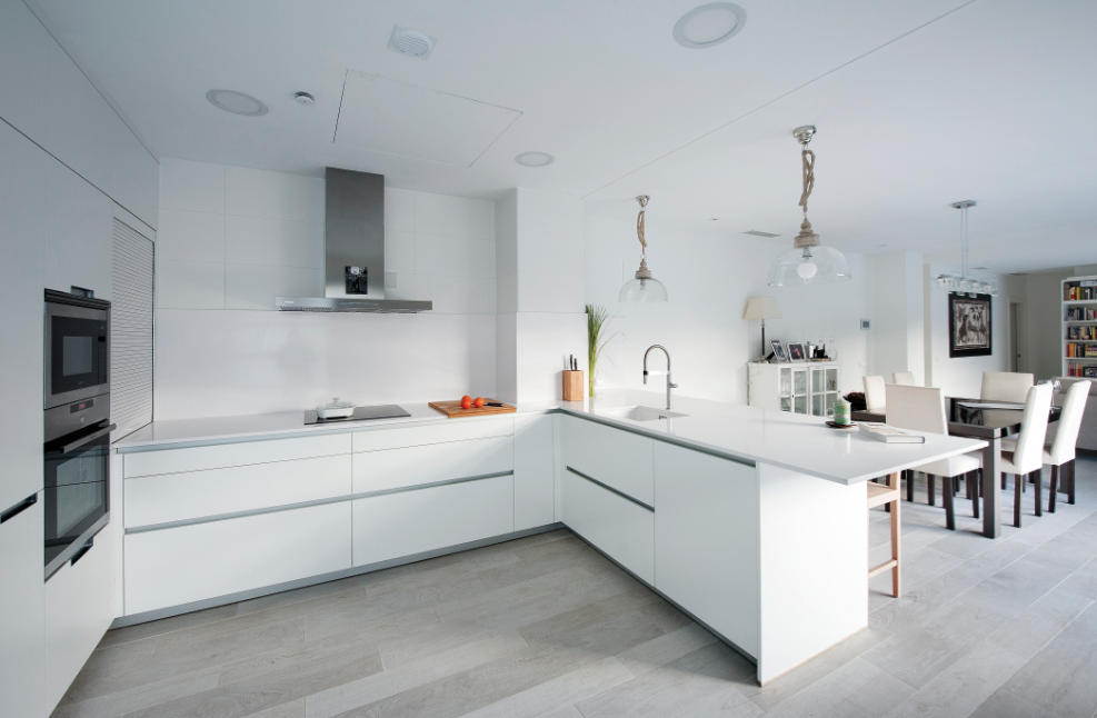 Puertas abiertas: una cocina discreta y blanca conectada con el salón