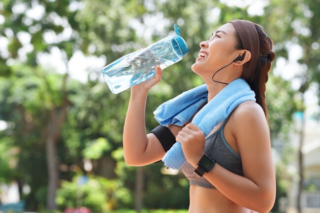 Happy Sportswoman Drinking Water In Park 1