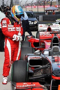 Fernando Alonso echando un vistazo al McLaren MP4-25 de Jenson Button en el parque cerrado