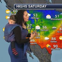 Una madre lleva a su hijo al trabajo para acompañarla mientras da el clima y así promover el porteo