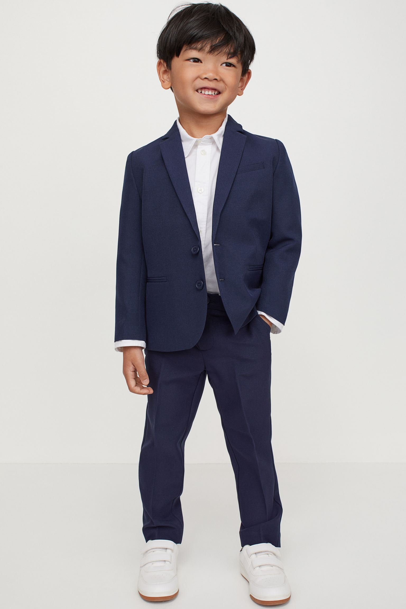 Pantalón de traje con cinturilla elástica ajustable, cierre de cremallera con botón, bolsillos al bies y un bolsillo decorativo detrás.