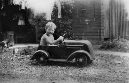 Niño jugando con un coche de pedales