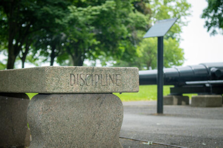 Banco de piedra en cuyo lateral está grabada la palabra discipline (disciplina, en inglés)