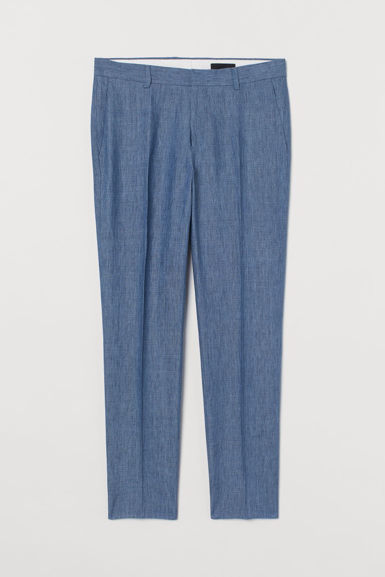 Pantalón tobillero de traje en lino vaporoso. Modelo con cierre de corchete y cremallera, bolsillos al bies, bolsillos traseros ribeteados y perneras pitillo con raya. Corte ajustado en muslo, rodilla y tobillo para una silueta depurada.