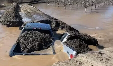 Una Chevrolet Silverado y una Ford F 150 convertidas en dique improvisado