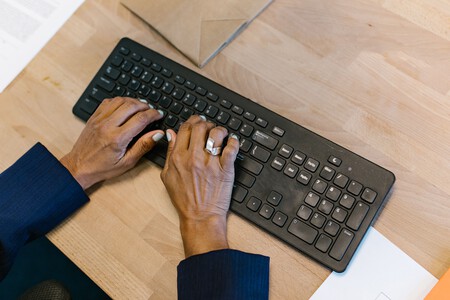 Mulher digitando em um teclado preto