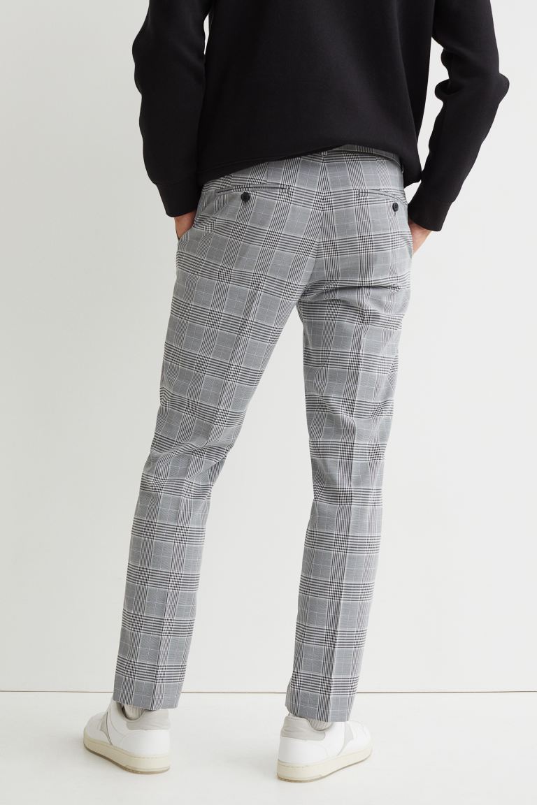 Pantalón de tela con raya. Modelo con cierre de cremallera, corchete oculto y botón en la pretina, bolsillos al bies y bolsillos traseros ribeteados con botón.