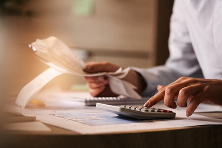 Mujer usando calculadora para manejar sus gastos