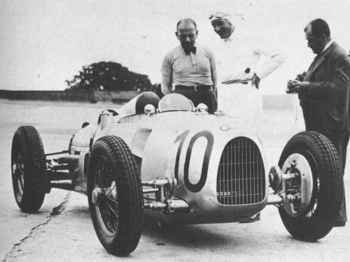 Ferdinand Porsche junto a su creación