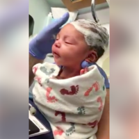 El enorme placer de una bebé recién nacida mientras lavan su pelo por primera vez