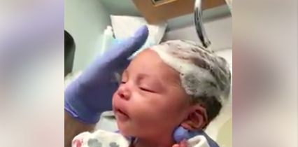 El enorme placer de una bebé recién nacida mientras lavan su pelo por primera vez