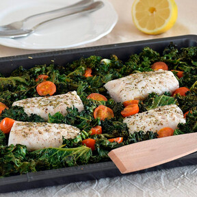 Lomos de merluza con col kale y tomatitos: receta saludable cocinada al horno en la misma bandeja