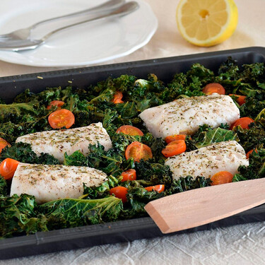 Lomos de merluza con col kale y tomatitos: receta saludable cocinada al horno en la misma bandeja